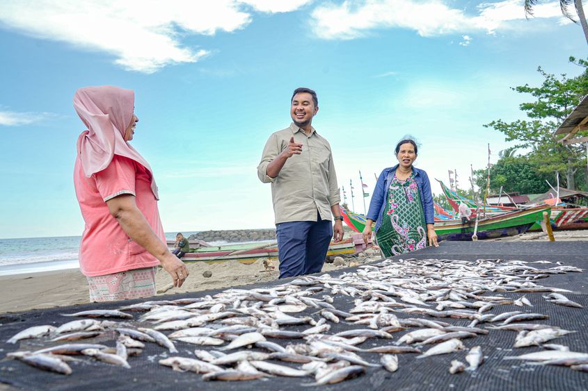 Photo 1 - Andi Taufan with Fitriawati (left) and her team in front of her rows of sun dried salted fish in Koto Tangah, Padang, West Sumatera (1) (1).jpg